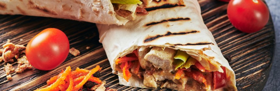 Eastern traditional shawarma with chicken and vegetables, Doner Kebab with sauces on slate. Fast food. Eastern food.